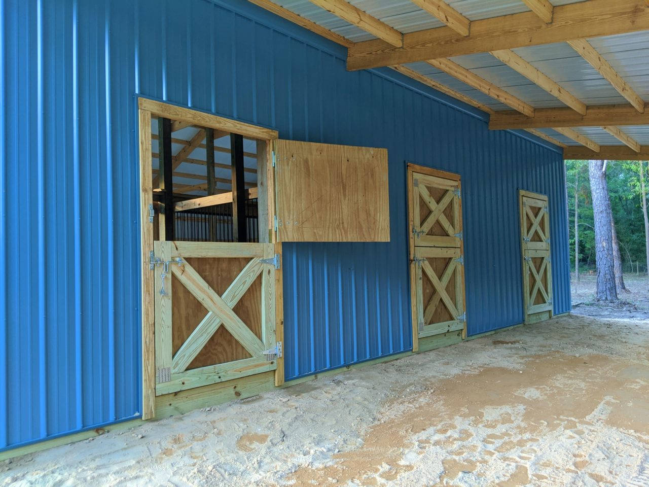 https://www.rpsmetalroofing.com/wp-content/uploads/2022/02/wooden-barn-doors-blue-metal-siding-1280x960.jpg